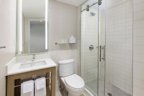 A modern bathroom with a glass-enclosed shower, a white sink, and a toilet. - Courtyard by Marriott New York Downtown Manhattan/Financial District (New York)