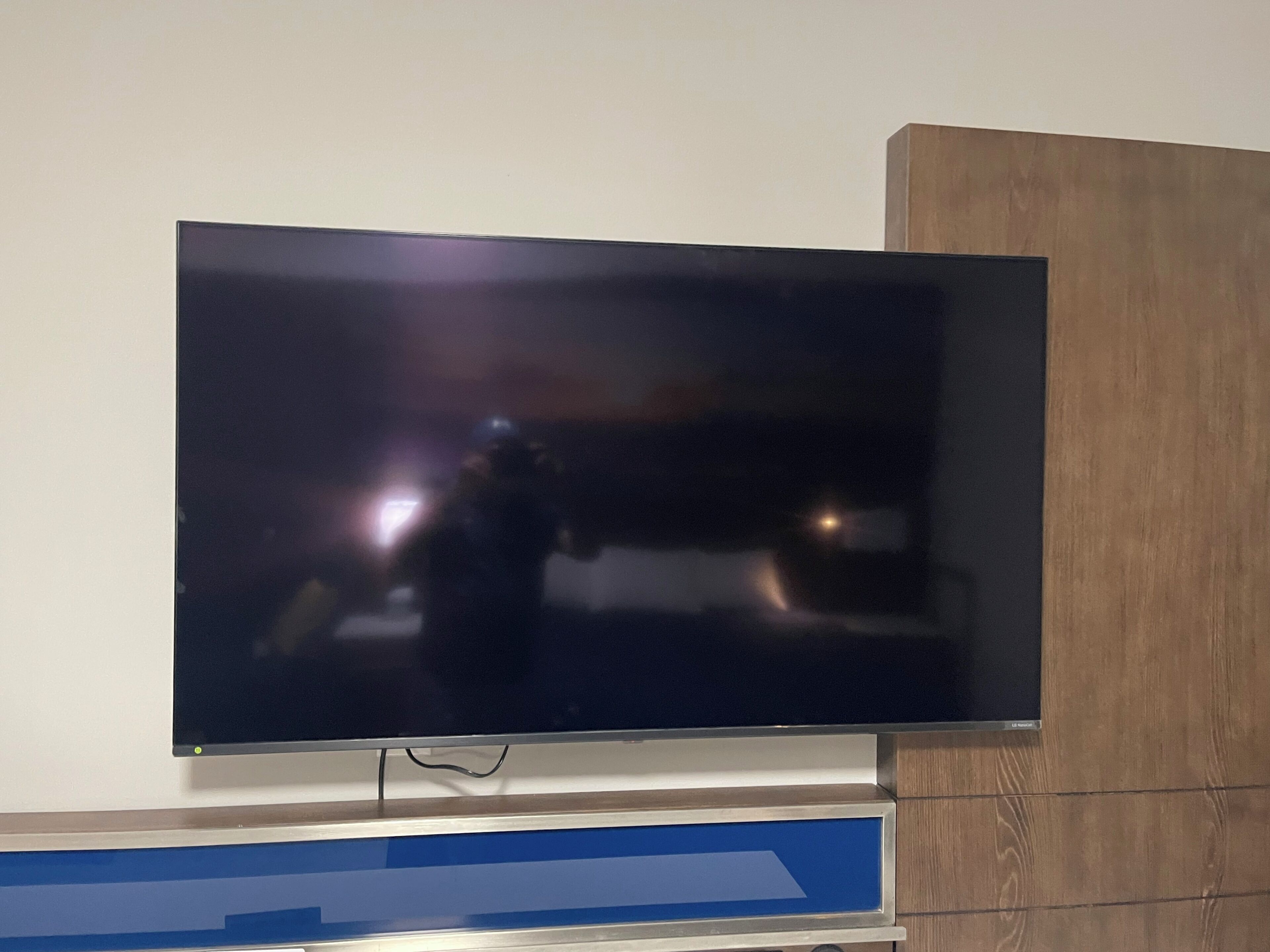 Un téléviseur à écran plat fixé sur un meuble en bois.