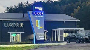 A building with a sign for 'LUXOR INN & SUITES' and a 'LUXOR' logo.