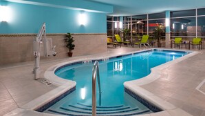 Une piscine intérieure dotée d’un système de filtration à eau claire, d’un poste de surveillance pour les sauveteurs et de plusieurs chaises longues.