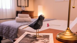 A bed with a white pillow and a blanket, a bedside table with a lamp, and a magazine on the table. - Family friendly house close to the beach (Κριθάρια)