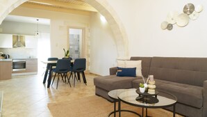 Un salon moderne comprenant un canapé, une table basse et un coin repas avec des chaises et une table.