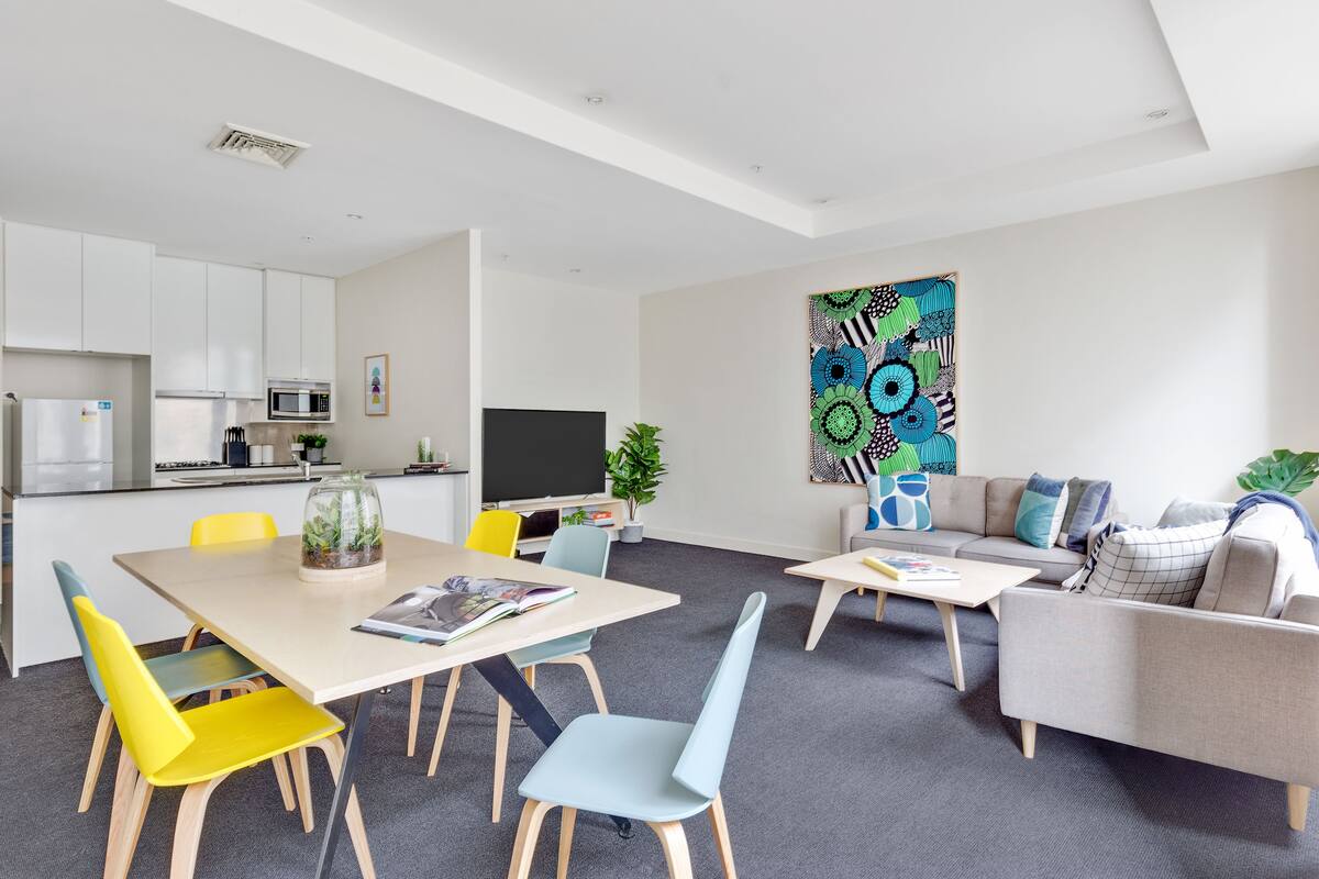 A modern living space with a dining area, kitchen, and seating area.