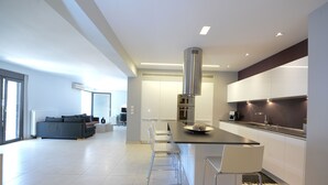 A modern kitchen with a central island, bar stools, and a dining area. - Prime 3BR/2BA Apt Heart of Heraklion-Fiber WIFI–Steps to Lions Sq Walk to Port 2 (Ηράκλειο)