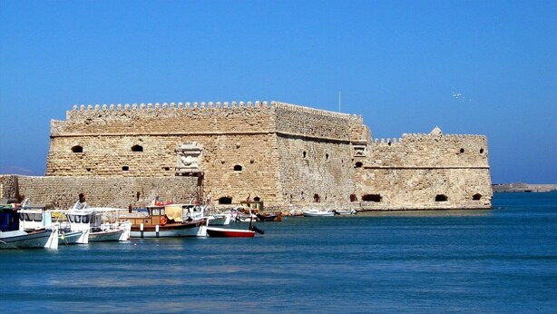 A historic stone fortress with a moat, boats docked in front, and clear blue skies. - Prime 3BR/2BA Apt Heart of Heraklion-Fiber WIFI–Steps to Lions Sq Walk to Port 2 (Ηράκλειο)