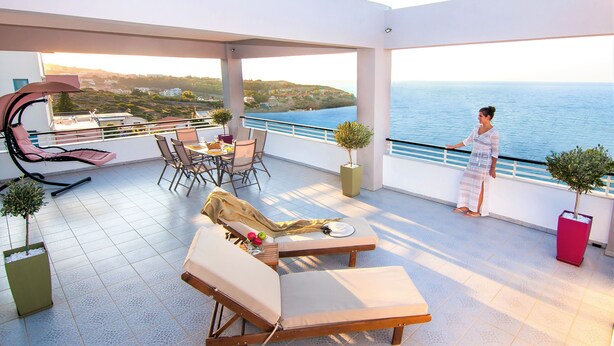 A spacious balcony with sun loungers, a dining area, and a view of the sea. - Villa Sea View (Ρέθυμνο)