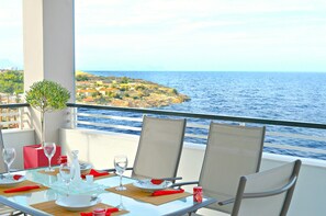 A table set for two with a view of the sea and a distant island.