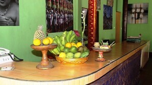 A reception area with a fruit display, a telephone, and a decorative vase. - agung trisna bungalows (Ubud)