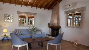 A living room with a sofa, two chairs, a coffee table, and a fireplace. - Summer Breeze House * with private pool * private parking * (Χανιά)