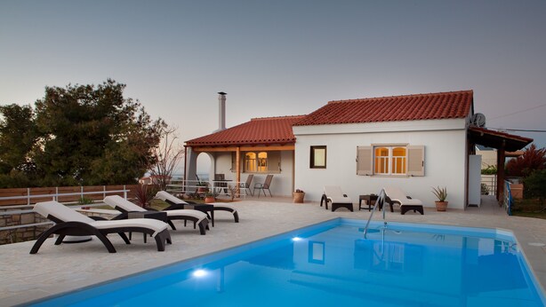 A swimming pool with lounge chairs and a building with a red-tiled roof. - Summer Breeze House * with private pool * private parking * (Χανιά)