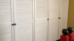 A set of white louvered closets with black handles, a beige wall, and a black floor. - Guest House near Kiev  (Софиевская Борщаговка)