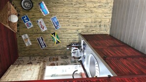 A small laundry room with a washing machine, a dryer, and a wooden floor. There are several stickers on the wall, including one that says "FL" and another that says "South Beach." - Guest House near Kiev  (Софиевская Борщаговка)