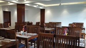 A dining area with wooden tables and chairs, arranged in a spacious layout. - The Euphoria Grand (Shimla)