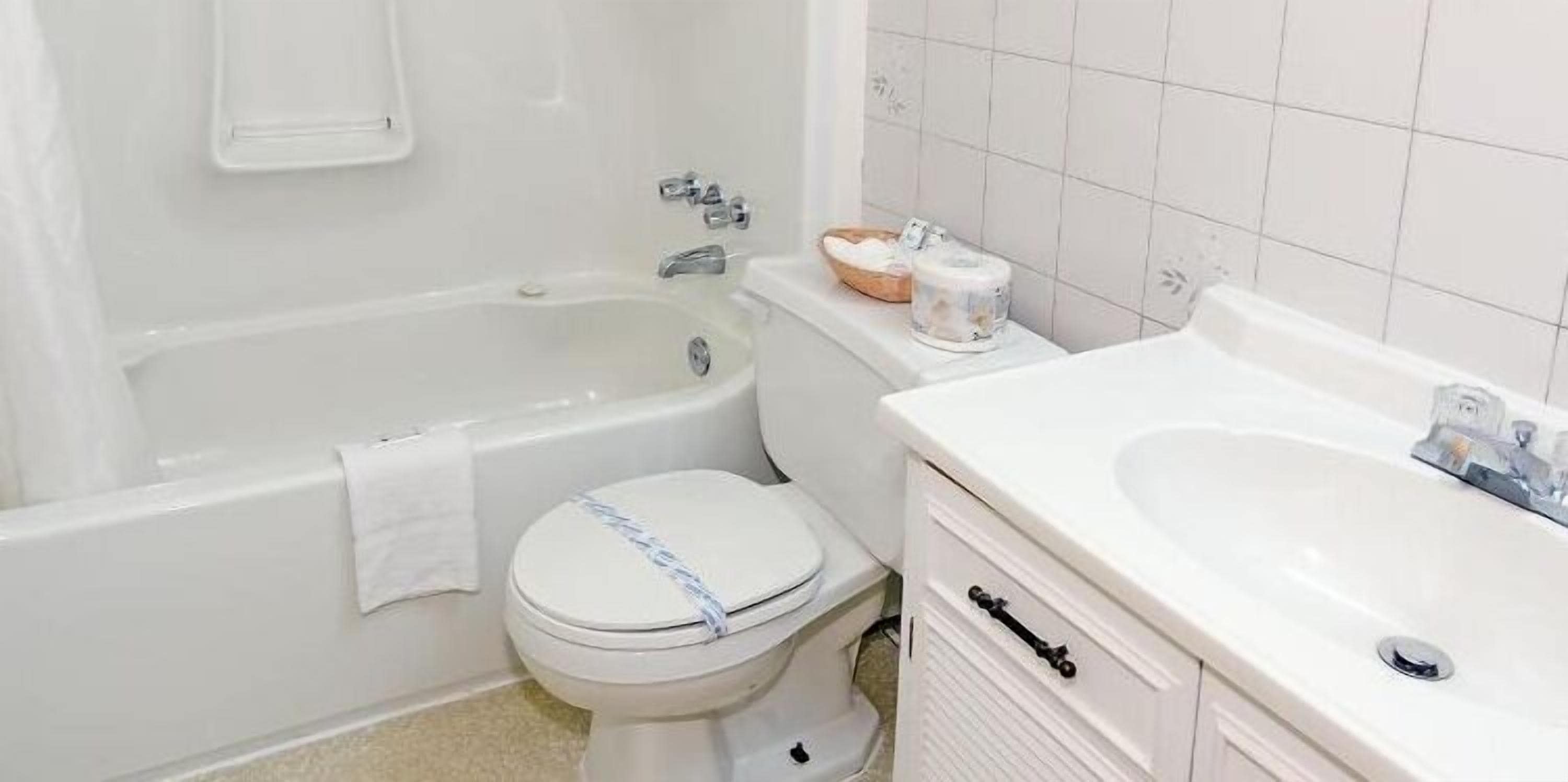 A bathroom with a bathtub, toilet, and sink.