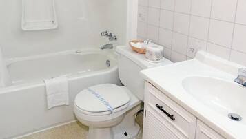 A bathroom with a bathtub, toilet, and sink.