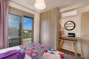A bedroom with a bed, a desk, and a wardrobe.