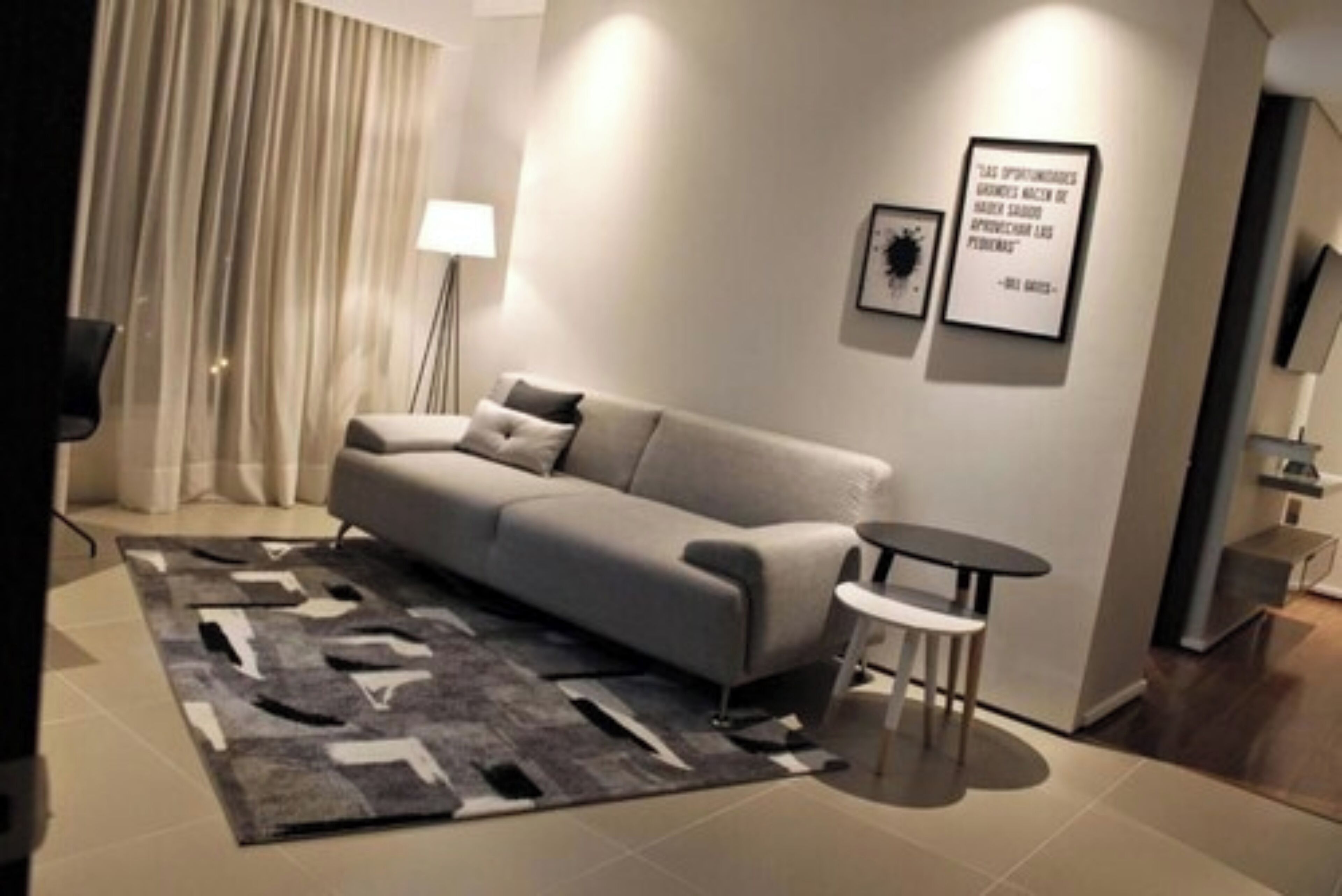 Una sala de estar moderna con un sofá, una mesita redonda y una alfombra decorativa.