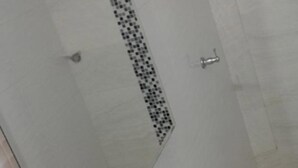 A bathroom with a shower, toilet, and bidet. - moskafamily (Cartagena)