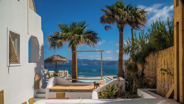 Un área de piscina con jacuzzi, sillas de descanso y una pérgola de madera.