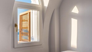 Un dormitorio con un ventanal grande, una cama y una manzana verde sobre la cama.