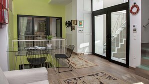 A modern living space with a balcony, a staircase, and a dining area. - Tripodon Plaka in the shade of Acropolis by GHH (Athens)
