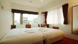 Una habitación de hotel con una cama grande, un escritorio, una silla, una ventana con cortinas y un espejo.