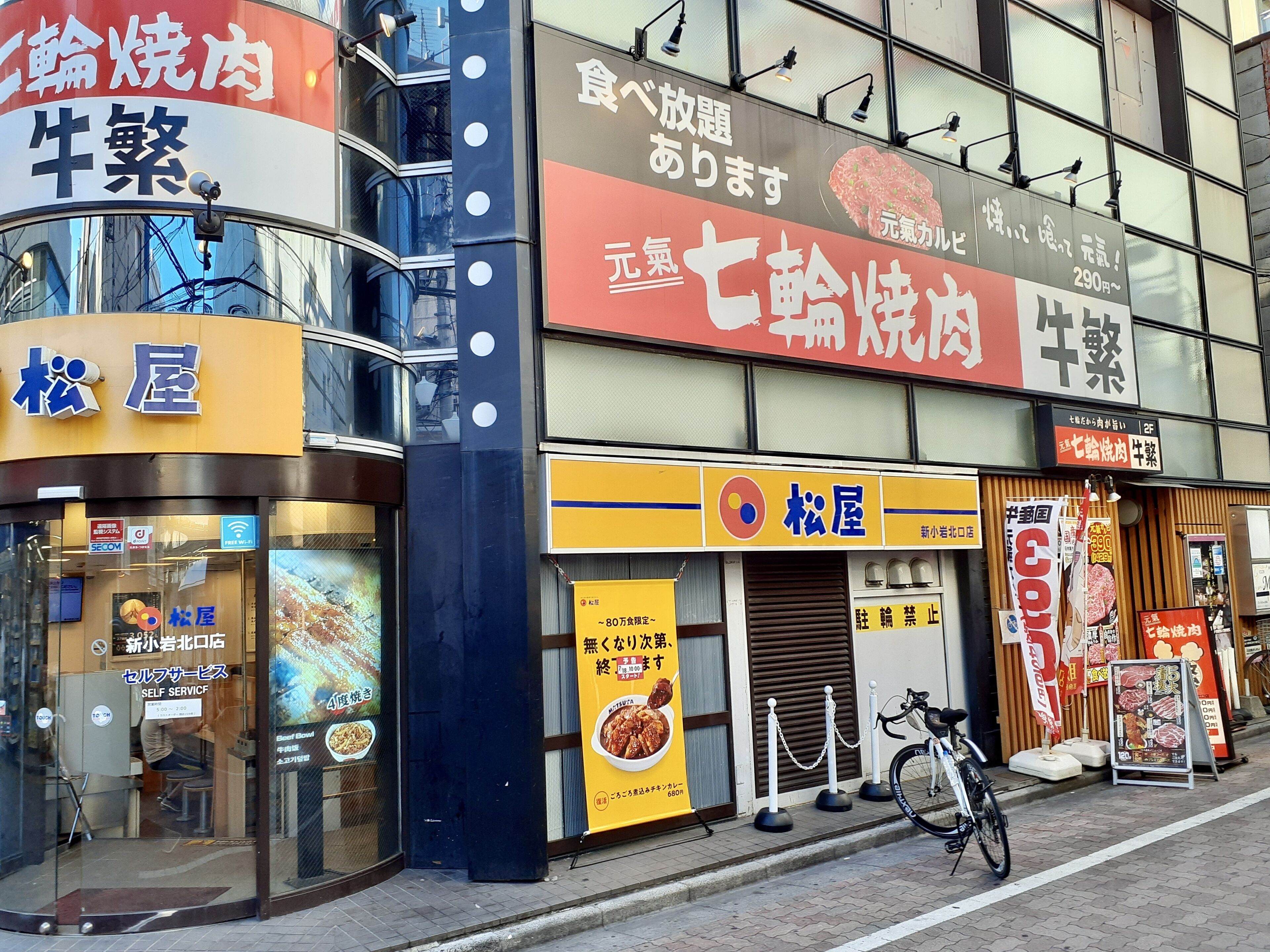 Ein Gebäude mit mehreren Schildern, die verschiedene Dienstleistungen und Produkte bewerben, darunter ein Restaurant und eine Selbstbedienungsanlage.