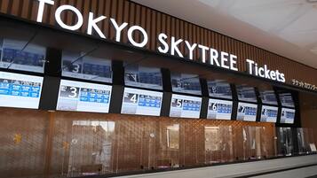 A Tokyo Skytree Ticket office with a large sign and ticket display boards.