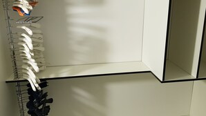 Un meuble de rangement blanc, doté de plusieurs compartiments, probablement destiné à ranger des effets personnels.