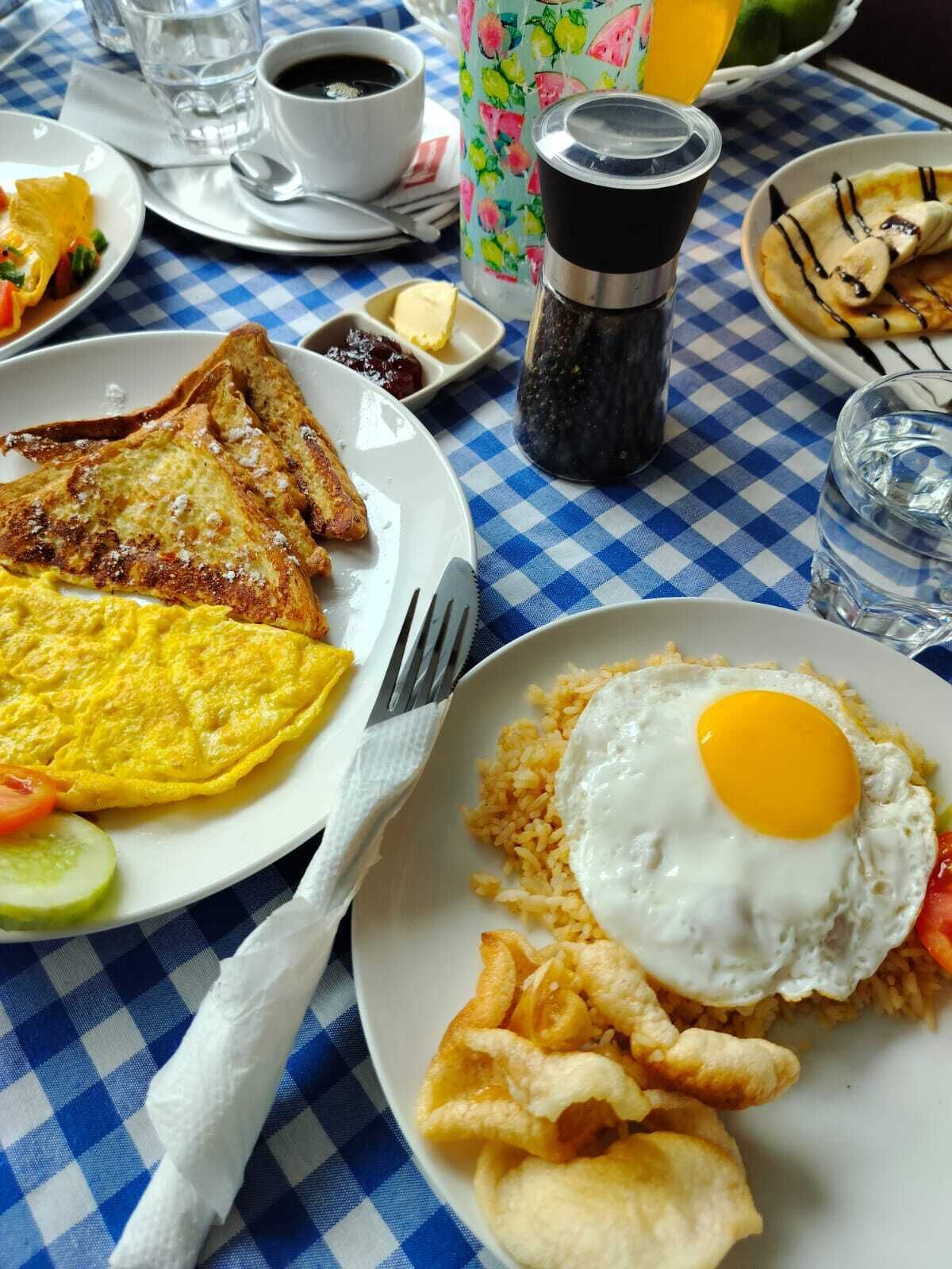 Een ontbijt met toast, roerei en gebakken rijst op een geruit tafelkleed.