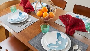 A wooden dining table set with plates, cutlery, and a fruit basket. - Senior villa 4BR, Shinjuku Okubo (東京)
