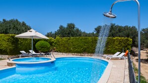 A swimming pool with a showerhead, lounge chairs, and a hedge in the background. - Holiday villa with private pool (Ξηροκάμπι)