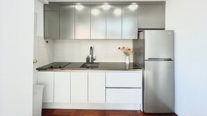 Eine moderne Küche mit weißen Schränken, Edelstahlgeräten und einer Holz Arbeitsplatte.