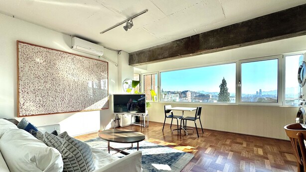 Ein modernes Wohnzimmer mit Sofa, Fernseher und Essbereich.