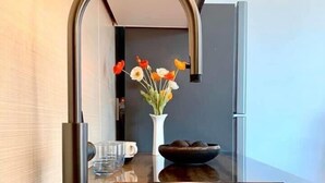 Eine moderne Küche mit einem eleganten schwarzen Spülbecken, einem Edelstahlarmaturen und einem Blumenstrauß auf der Arbeitsplatte.