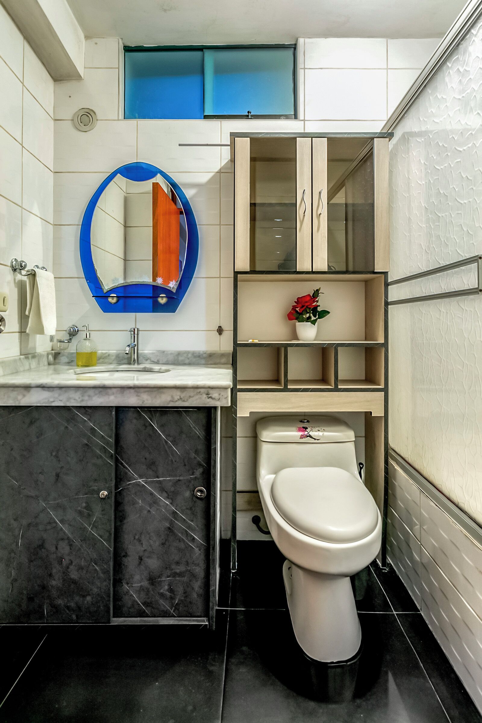 A modern bathroom with a toilet, sink, and mirror.