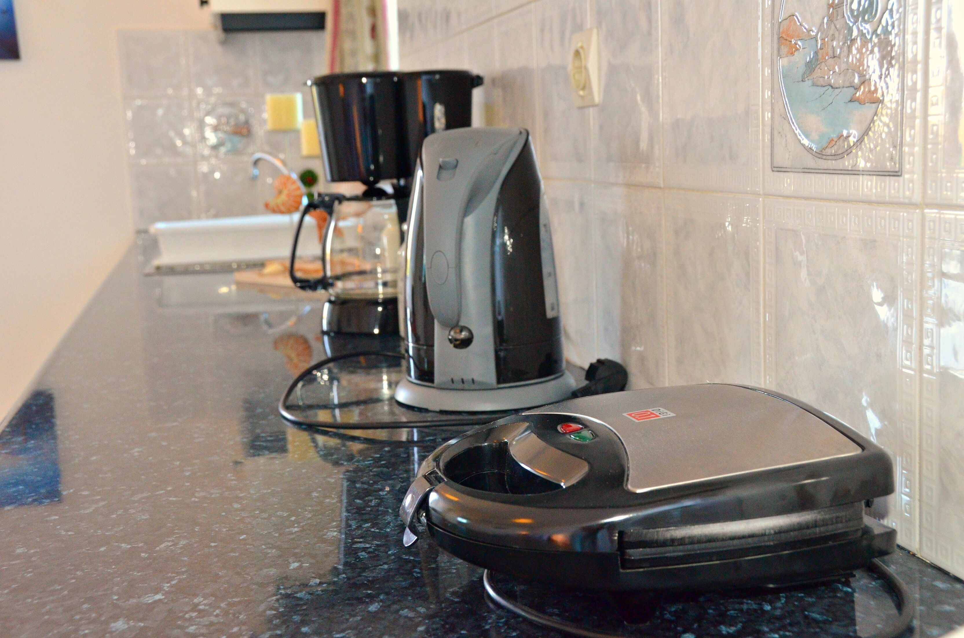 Una cocina con cafetera y tostadora sobre la encimera.