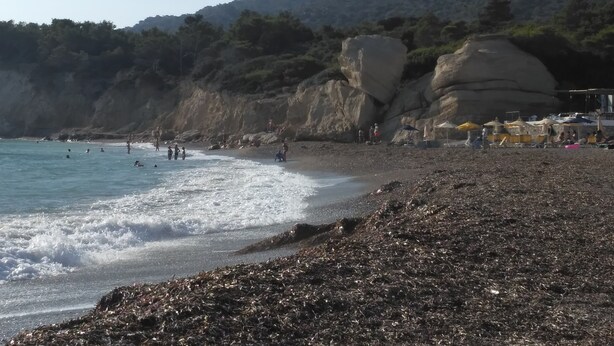 A beach with rocky terrain and a few people. - Apartment "Grace" with 2 spaces, at the foothills of Filerimos, Ialysos - Rhodes (Ιαλυσός)