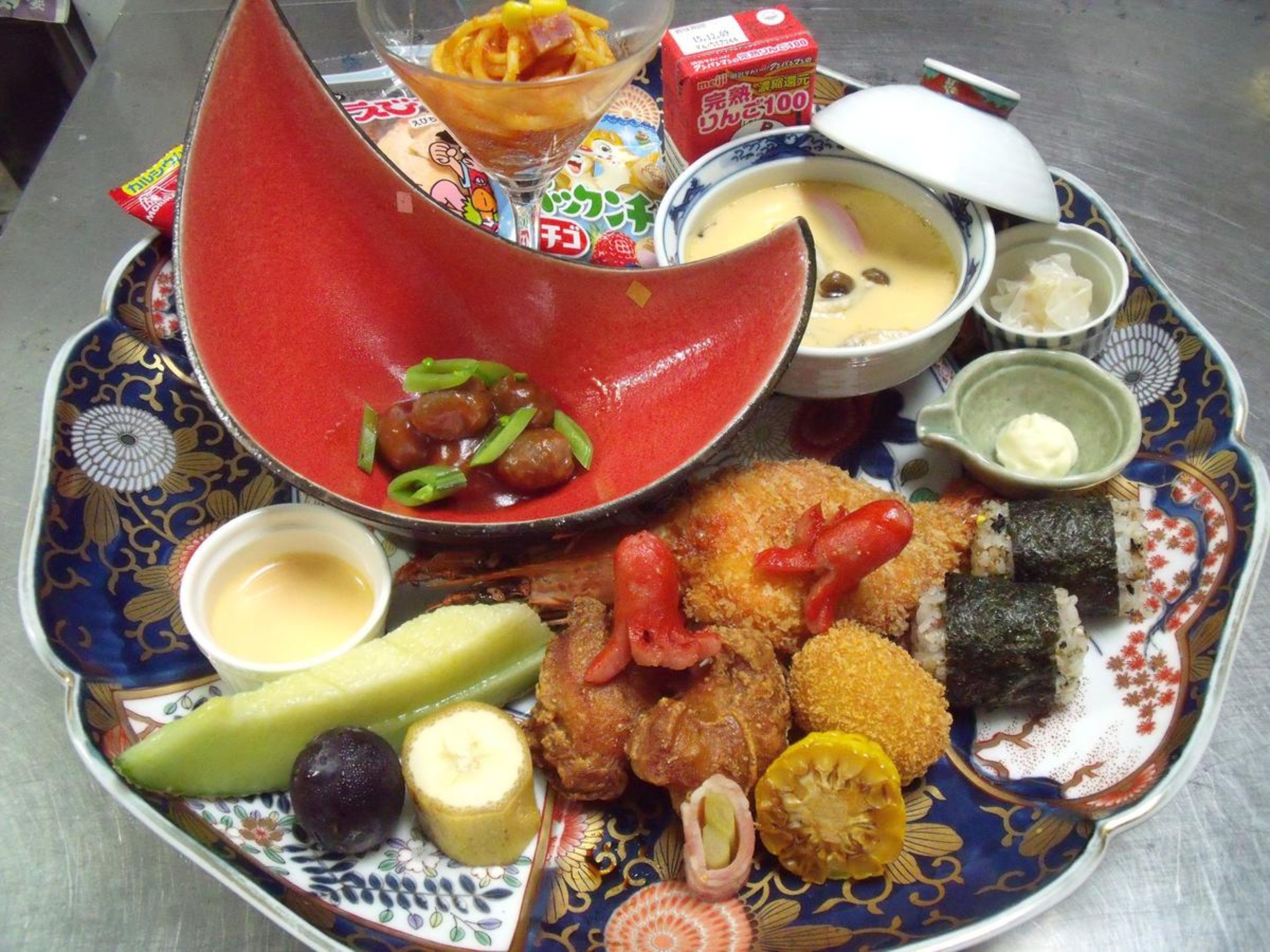 A traditional Japanese meal with various dishes including sushi, tempura, and a bowl of soup.