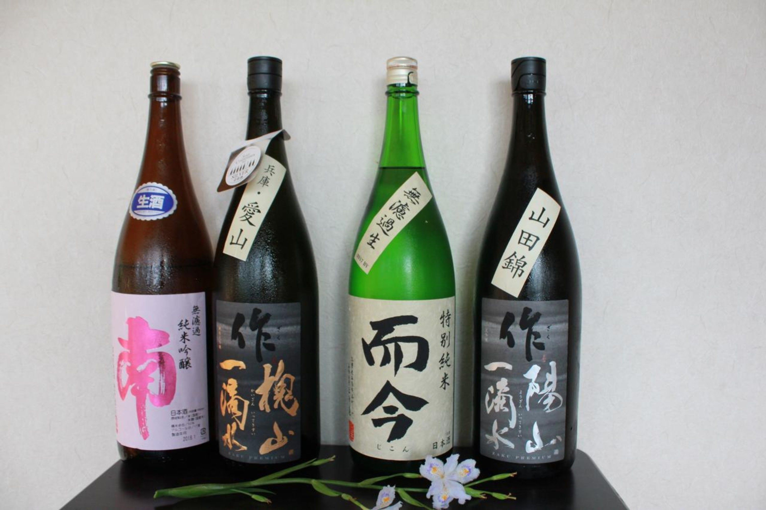 Neljä sake-pulloa, joissa on etiketit ja joissa kaikissa on japaninkielisiä merkkejä.