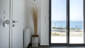 Une chambre moderne avec vue sur la mer, un radiateur, une porte avec une poignée et une plante en pot.