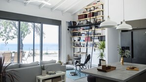 Une cuisine moderne dotée d’un grand îlot central, de bibliothèques intégrées et offrant une vue sur la mer.