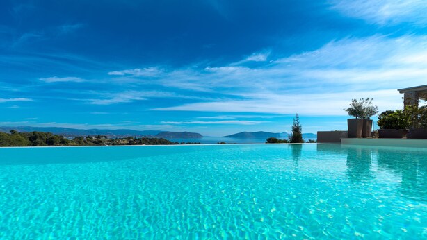 A clear blue pool with a view of distant mountains and a clear sky. - Villa Emmelia & Guesthouse Amazing View With Pool (Πόρτο Χέλι)