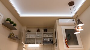Una cucina con mobili bianchi, una finestra e un lampadario.