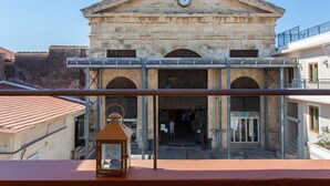 A historic building with a clock, arched entrance, and a balcony. - Agora Suites  - Stay in the HEART of CHANIA (Χανιά)