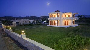 Une maison moderne à deux étages, dotée d’une pelouse bien entretenue et d’un mur en pierre.