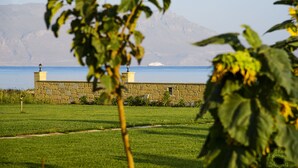 Un bâtiment en pierre offrant une vue sur la mer et les montagnes en arrière-plan.