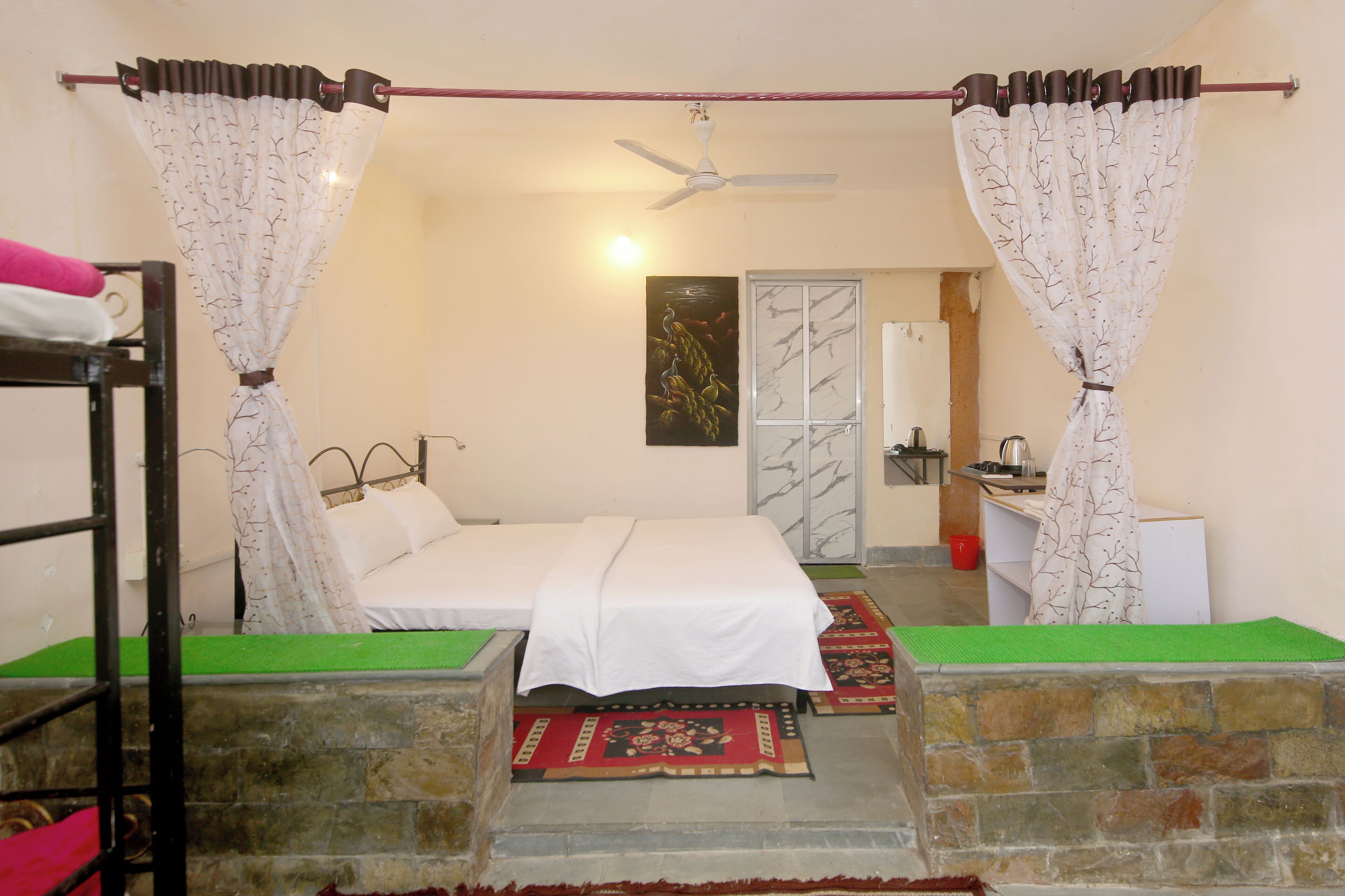 A room with a bed, a small table, a chair, a window, and a door.