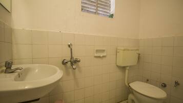 Un baño pequeño con lavamanos, inodoro y ventana.