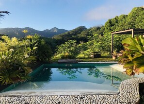 A serene outdoor pool area with a clear view of mountains in the background. - Te Fiti Island Break Mahina (Mahina)